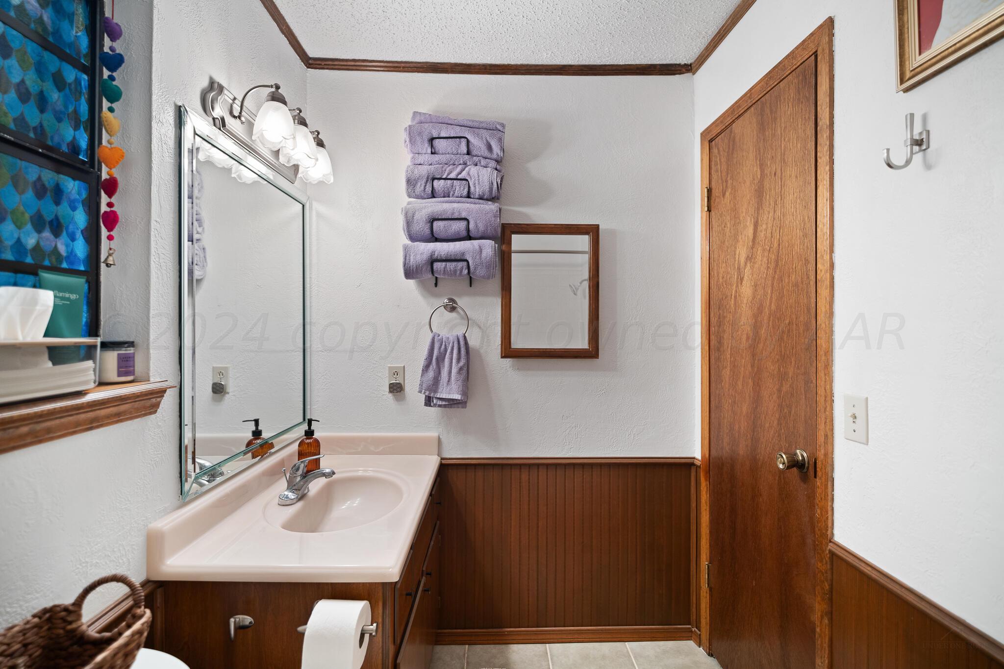 4202 Charles Street Amarillo, TX 79106 - Photo 19 of 25 a bathroom with a sink and mirror