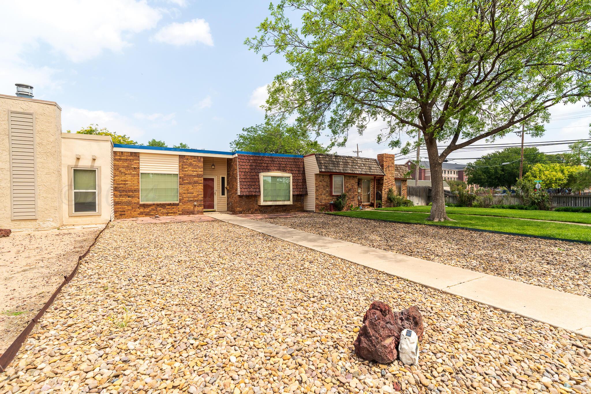4202 Charles Street Amarillo, TX 79106 - Photo 3 of 25 a front view of a house with a garden and trees