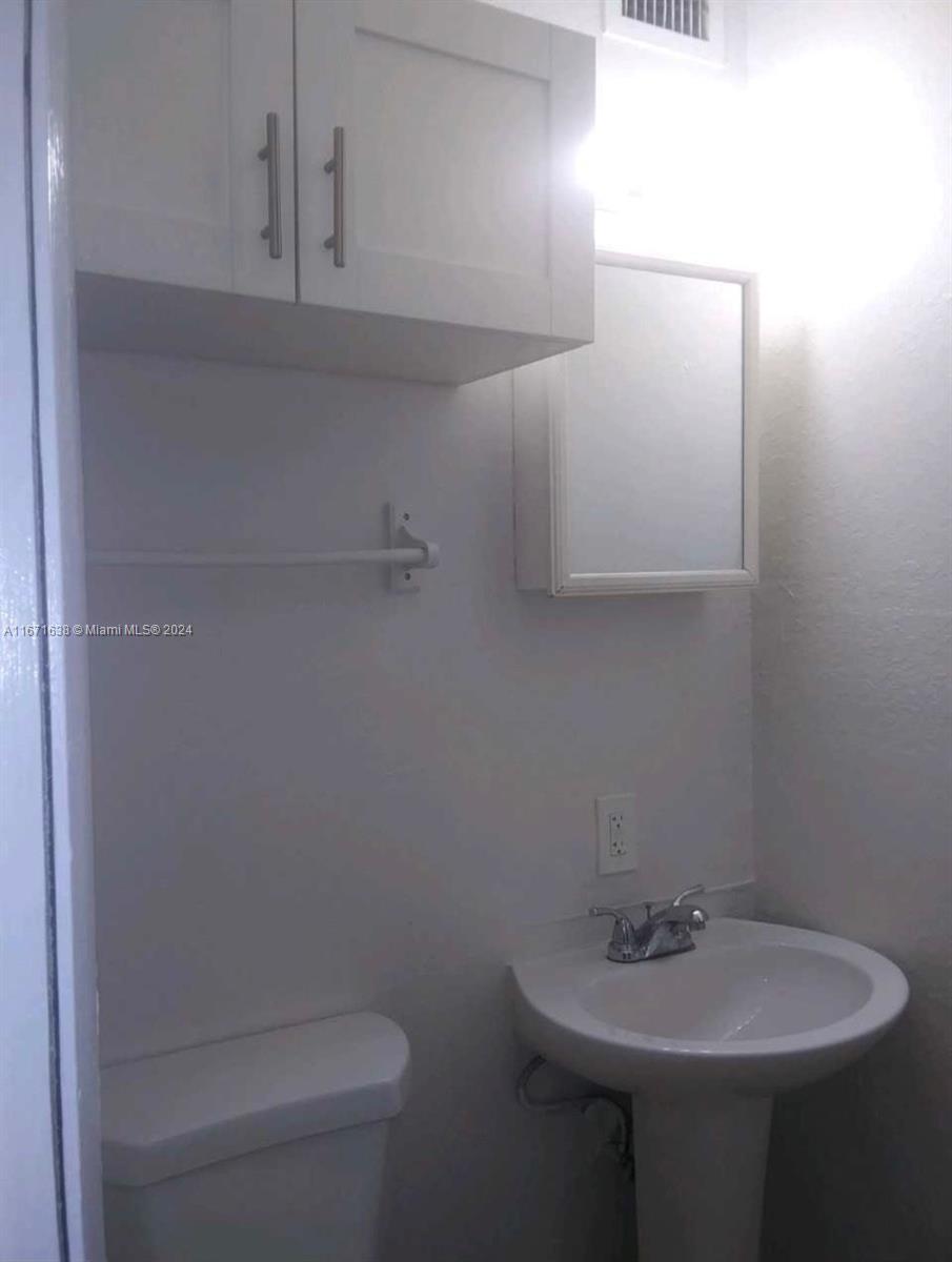 17325 Homestead Avenue, Unit 2 Miami, FL 33157 - Photo 3 of 5 a bathroom with a sink a toilet and mirror