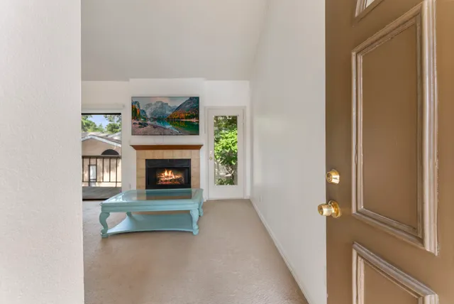 a view of an empty room with a fireplace and a window