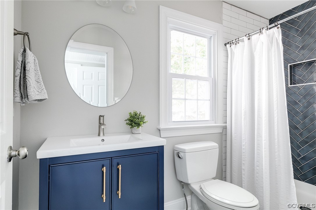 2225 Brookwood Road Richmond, VA 23235 - Photo 21 of 34 a bathroom with a toilet a sink a mirror and a window