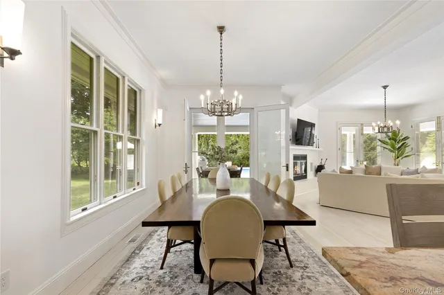 a dining room with furniture a chandelier and wooden floor