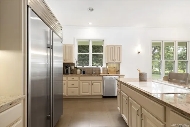 a kitchen with stainless steel appliances granite countertop a sink and a refrigerator