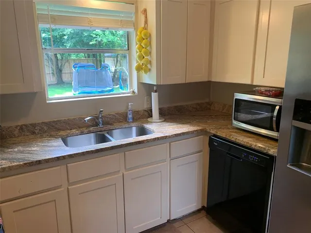 a kitchen with stainless steel appliances white cabinets and a sink