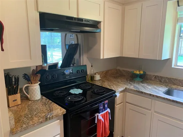 a kitchen with a stove and a white cabinets
