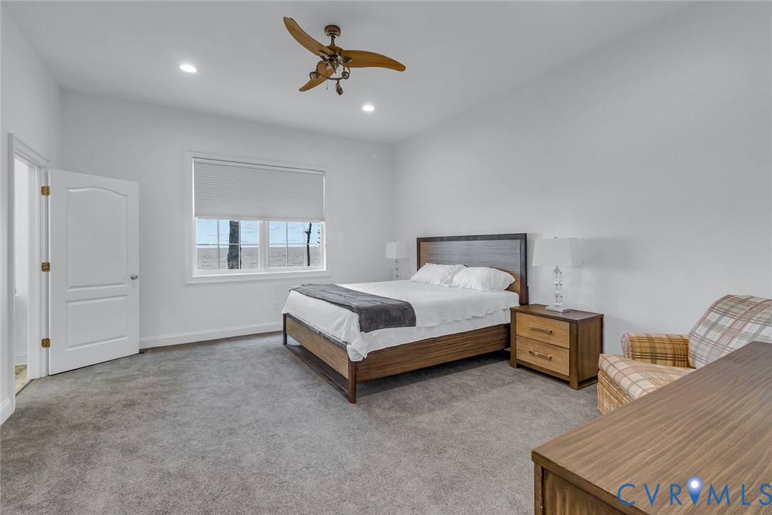 3315 Windmill Point Road White Stone, VA 22578 - Photo 26 of 49 a bedroom with a bed ceiling fan and a wooden floor