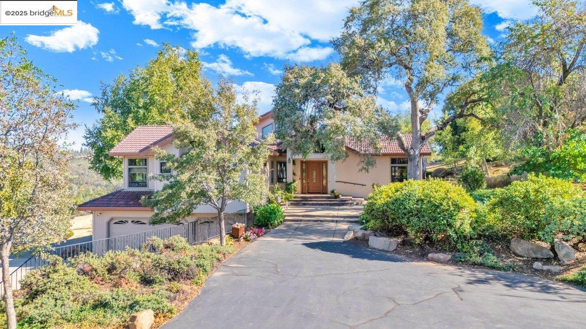 13700 Clements Road Groveland, CA 95321 - Photo 5 of 93 View of property hidden behind natural elements featuring a tile roof and stucco siding