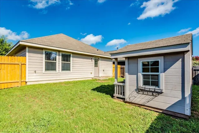 a view of a house with a big yard plants and large trees