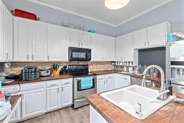 a kitchen with appliances a sink and cabinets