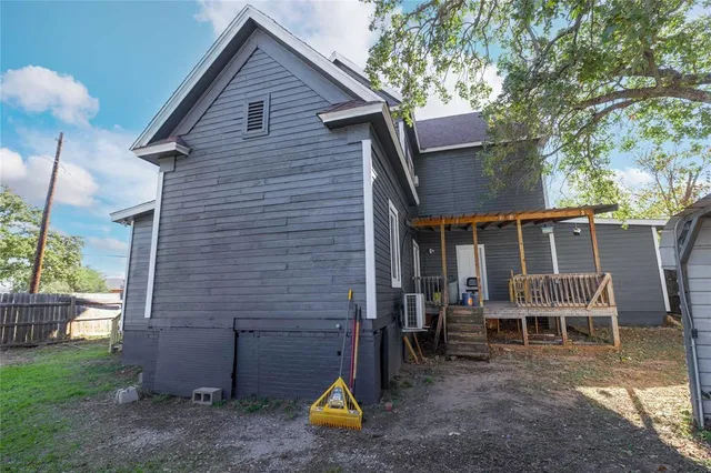 a view of house with a yard and a large tree