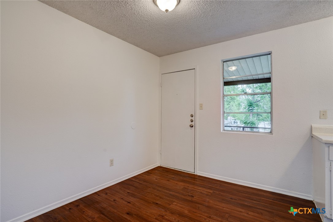 726 Old Martindale Road San Marcos, TX 78666 - Photo 11 of 18 a view of an empty room with wooden floor and a window
