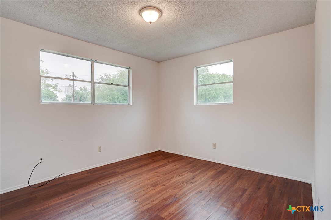 726 Old Martindale Road San Marcos, TX 78666 - Photo 10 of 18 an empty room with wooden floor and windows