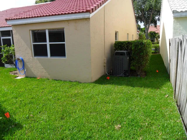 a view of an house with backyard space and a tree