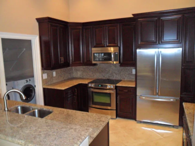 a kitchen with granite countertop a refrigerator and a sink