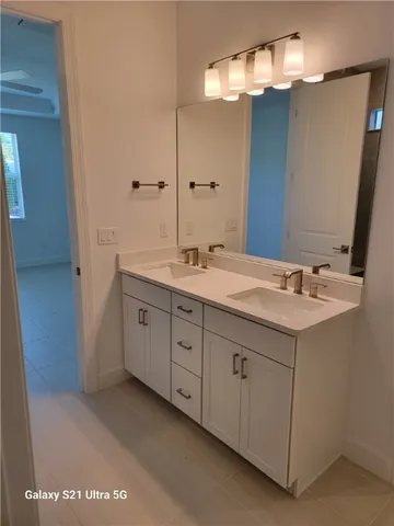 a spacious bathroom with a double vanity sink and a mirror