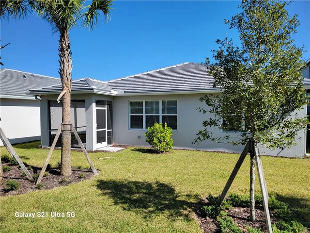 a view of a house with backyard sitting area and swimming pool