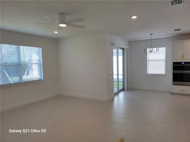 an empty room with windows and fireplace