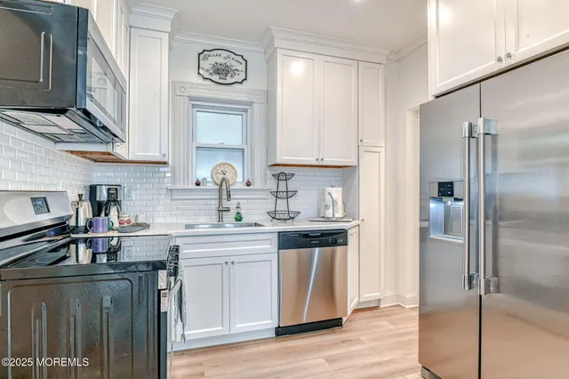a kitchen with stainless steel appliances granite countertop a refrigerator and a stove top oven