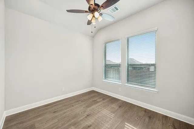 an empty room with a window and a ceiling fan