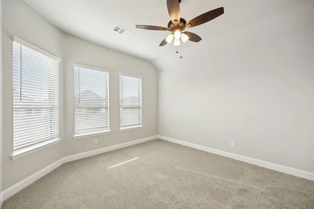 an empty room with a window and a fan