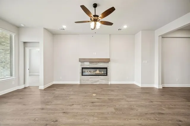 a view of an empty room with a ceiling fan and window