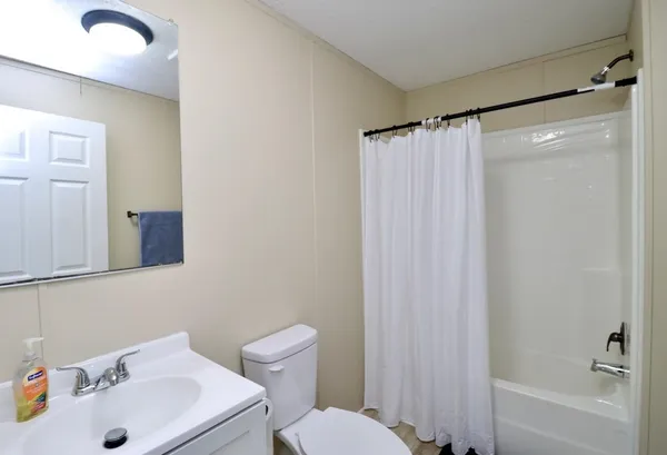 a bathroom with a sink a toilet and shower curtain