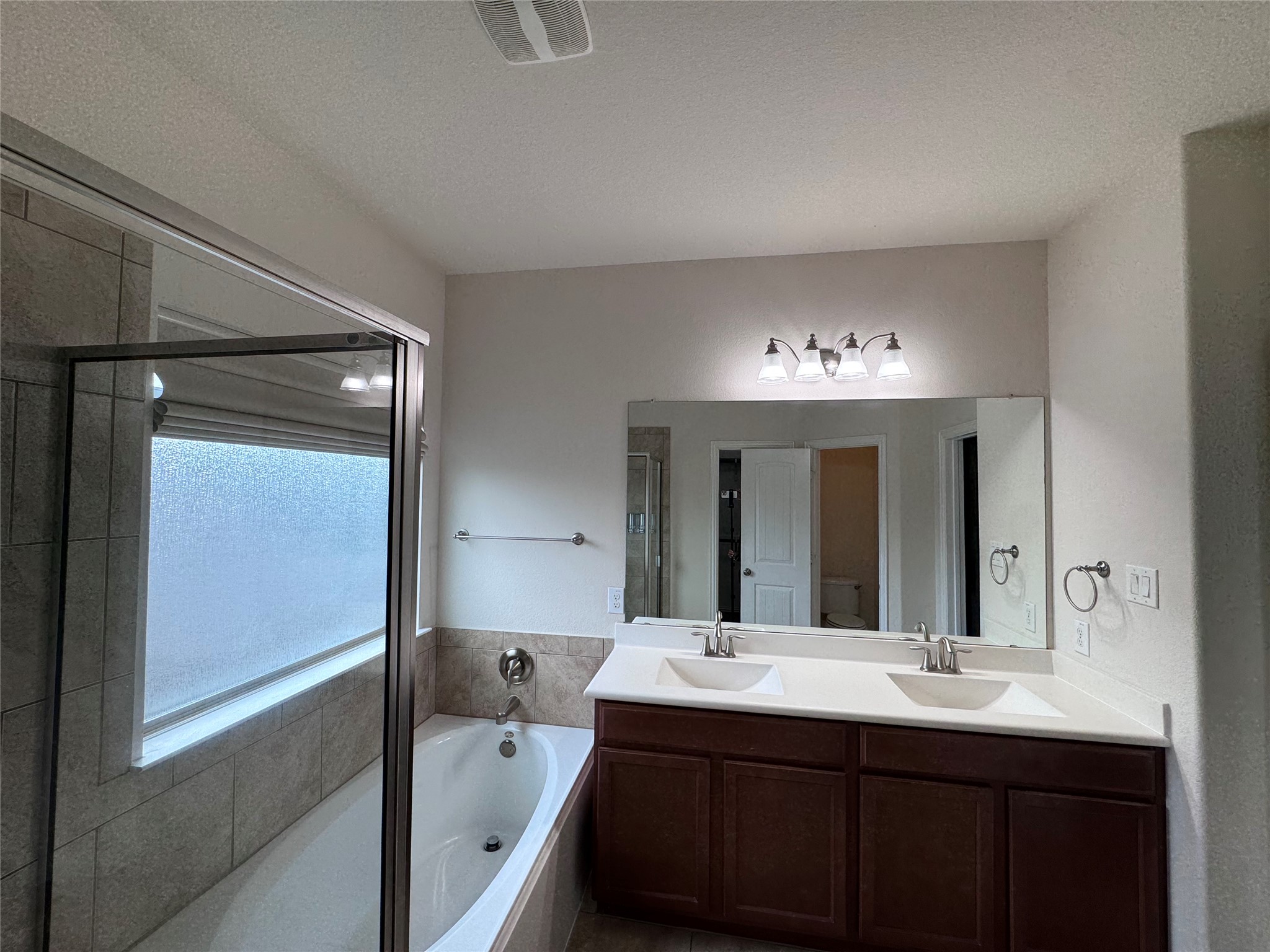 2605 Rough Berry Road Pflugerville, TX 78660 - Photo 35 of 40 Dual vanities and a deep soaking tub create a luxurious bathroom retreat.