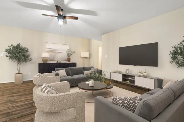 a living room with furniture and a large mirror with wooden floor