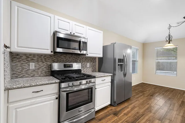 a view of a kitchen with wooden floor and a kitchen space