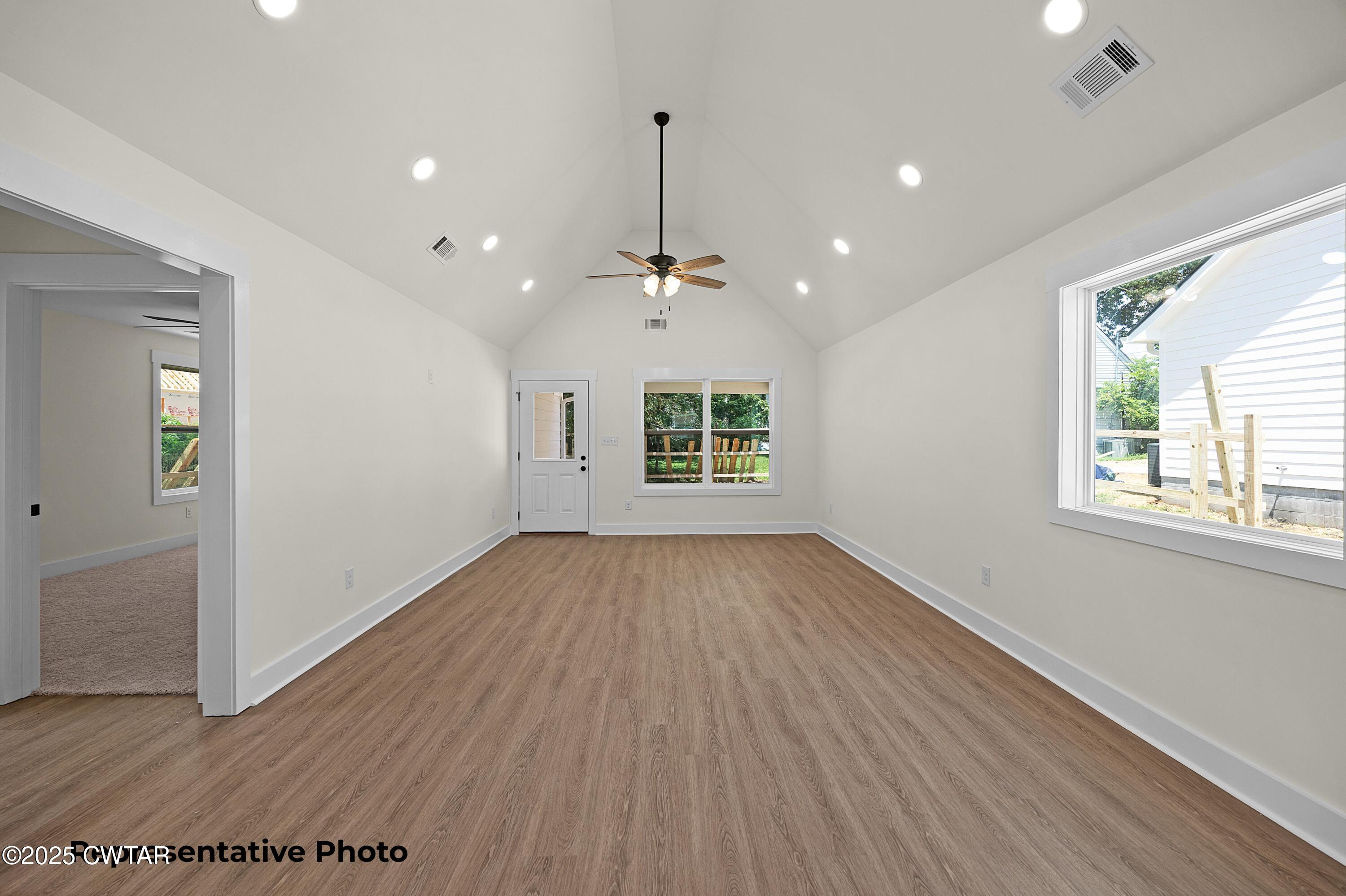 118 Roland Avenue Jackson, TN 38301 - Photo 4 of 24 an empty room with wooden floor and windows