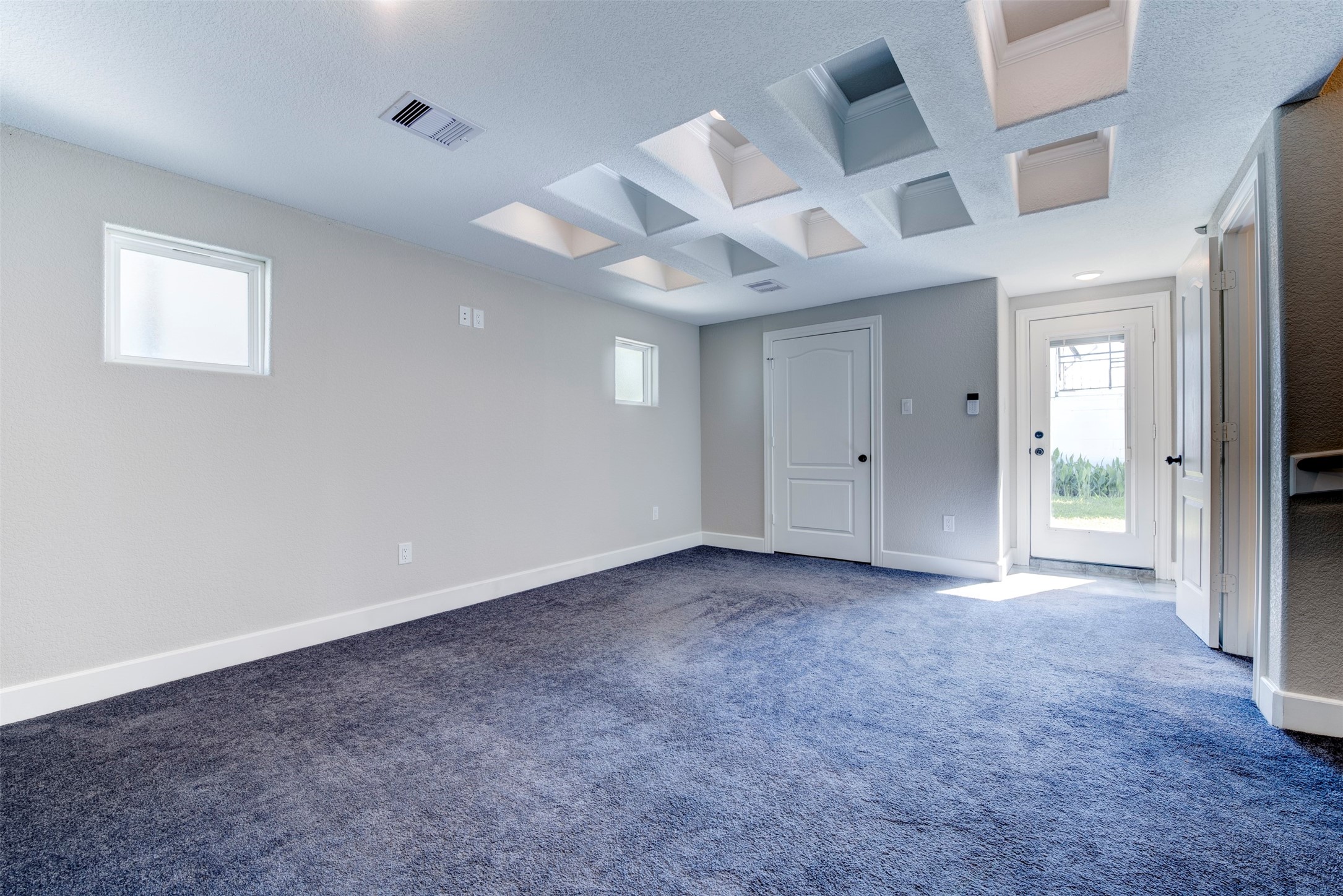 109 Dresden Street Houston, TX 77012 - Photo 27 of 43 Another view of the primaty bedroom, recessed ceiling design, and ample natural light from two small windows. Features a white door and glass-paneled with build in blinds exit to the outside patio.