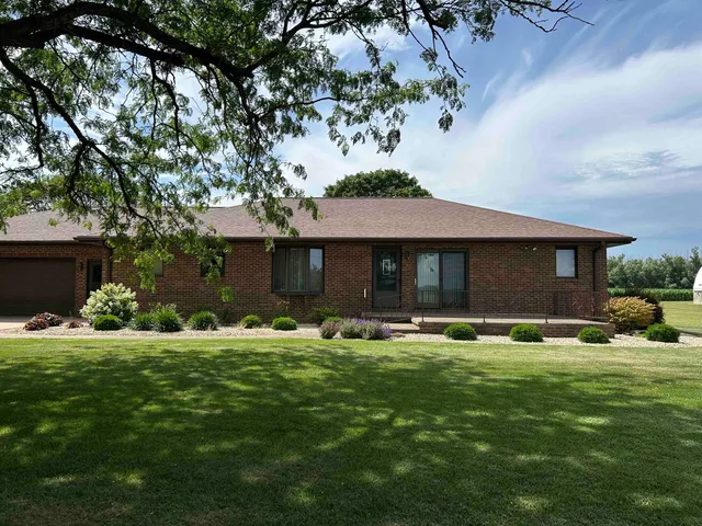 a front view of a house with a yard and trees