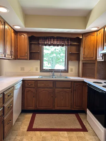 a kitchen with a sink window and cabinets