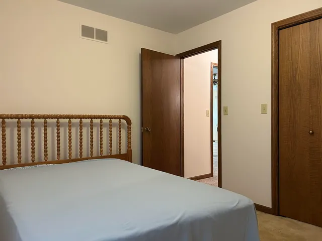 a bed sitting in a bedroom next to a window