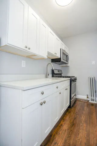 a kitchen with cabinets appliances a sink and a counter top space
