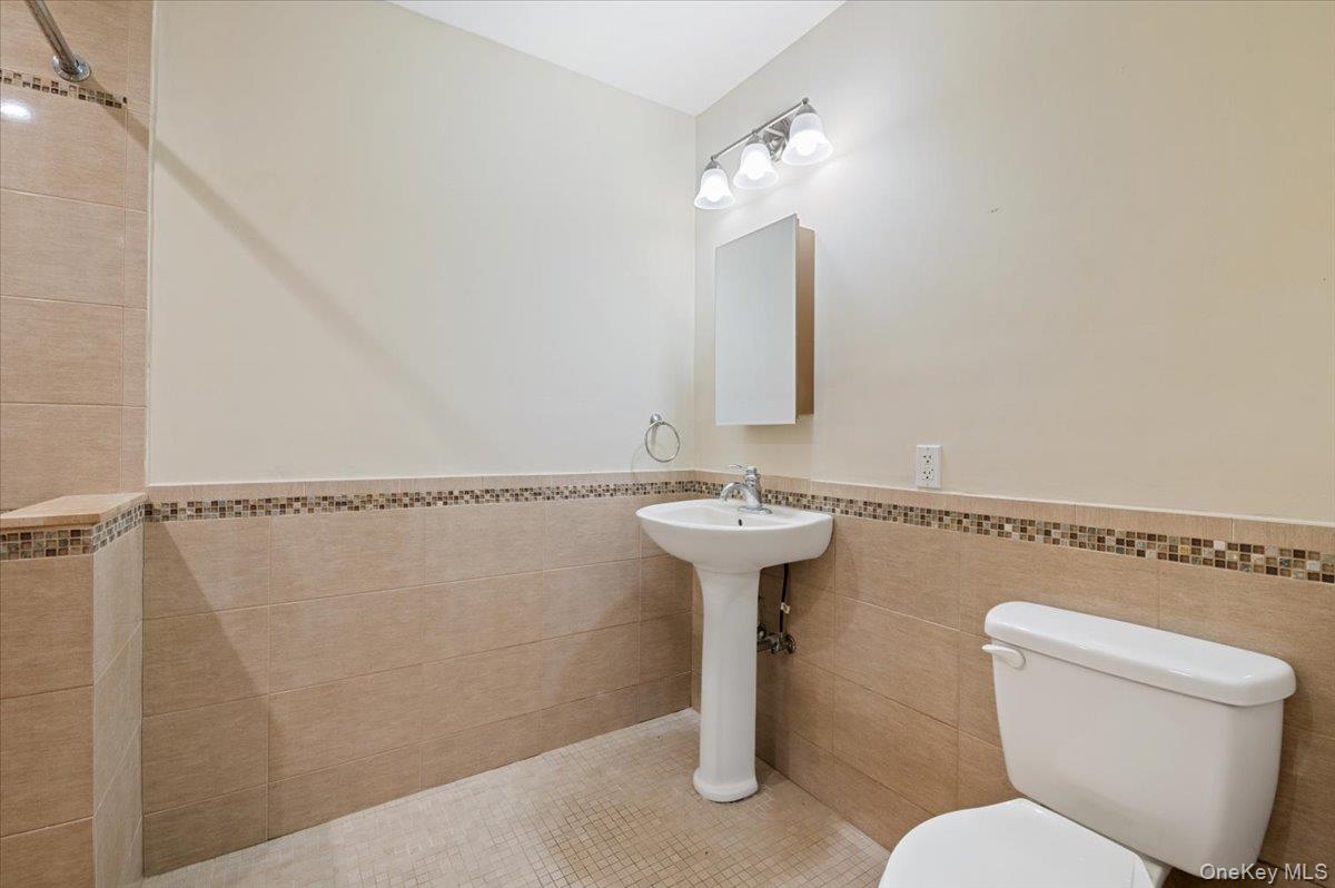 33 Fleets Cove Road Huntington, NY 11743 - Photo 31 of 42 Handicap Accessible Bathroom featuring a wainscoted wall and tile walls