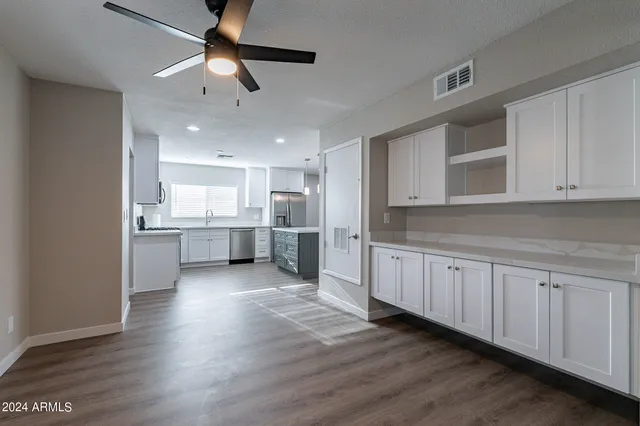 a large kitchen with stainless steel appliances cabinets a wooden floor and a sink