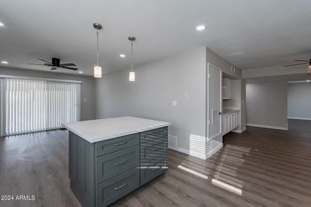 a kitchen with stainless steel appliances a refrigerator a sink dishwasher with a dining table and wooden floor