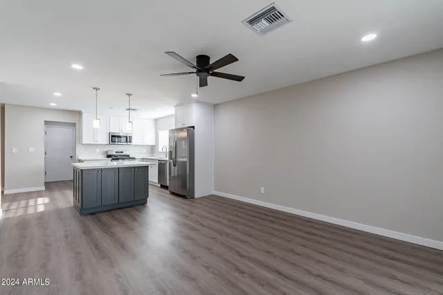 a living room with kitchen island furniture and a ceiling fan