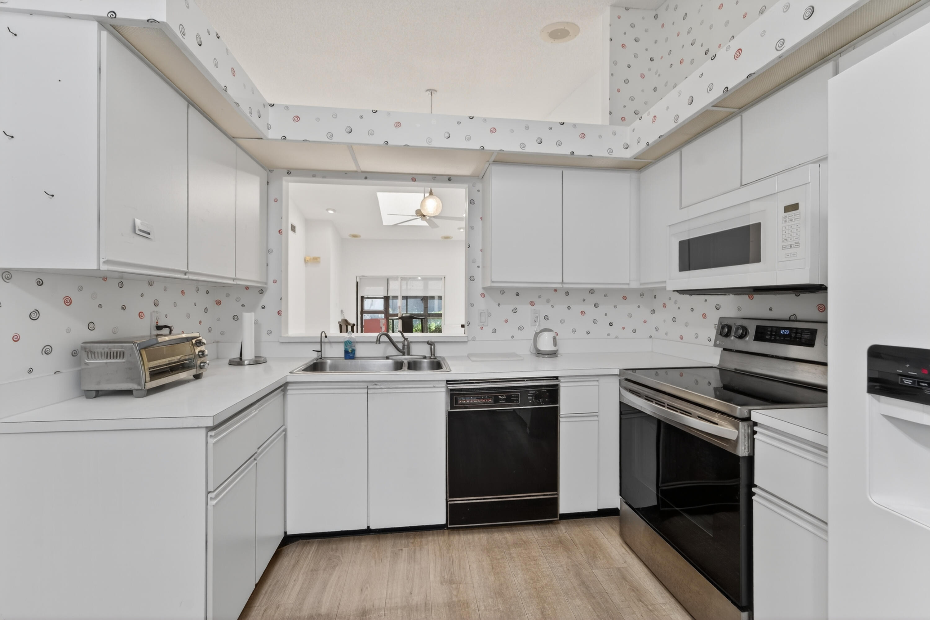 6371 Kings Gate Circle Delray Beach, FL 33484 - Photo 18 of 52 a kitchen with cabinets appliances a sink and a counter top space
