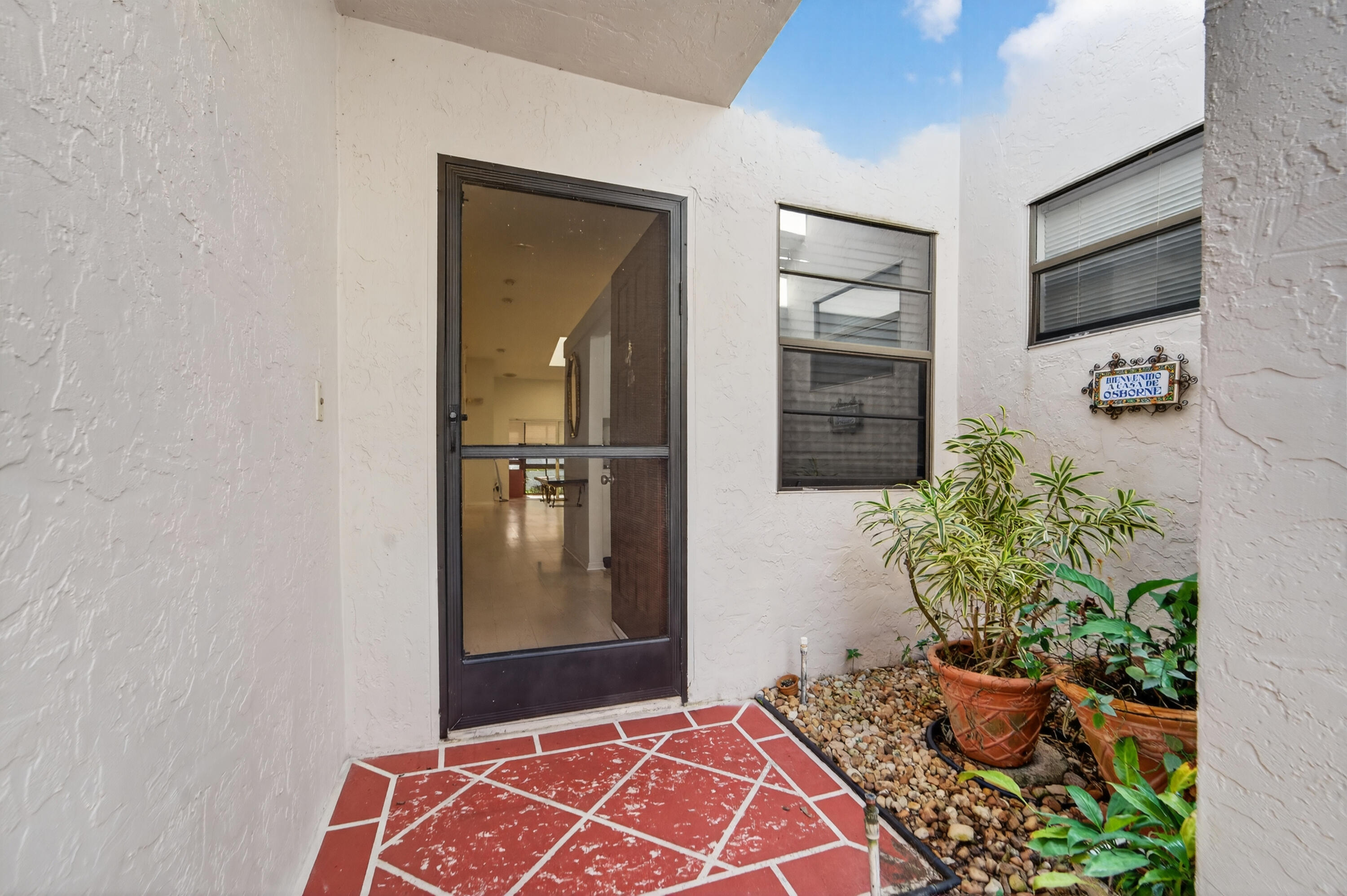 6371 Kings Gate Circle Delray Beach, FL 33484 - Photo 26 of 52 a hallway with front door and wooden floor