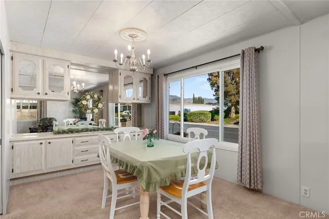 a dining room with furniture a chandelier and window