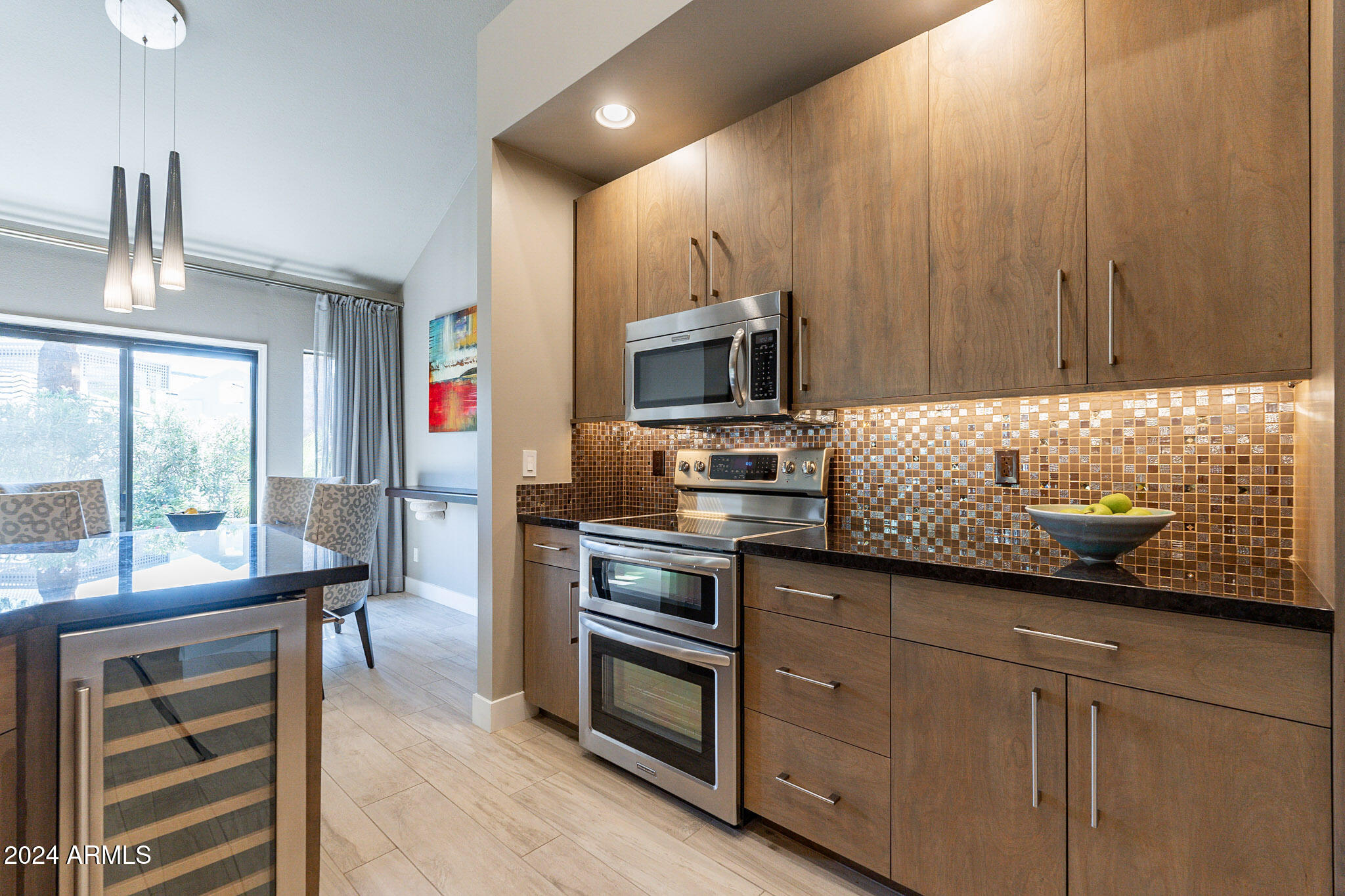 7272 East Gainey Ranch Road, Unit 101 Scottsdale, AZ 85258 - Photo 13 of 36 a kitchen with granite countertop wooden cabinets and stainless steel appliances
