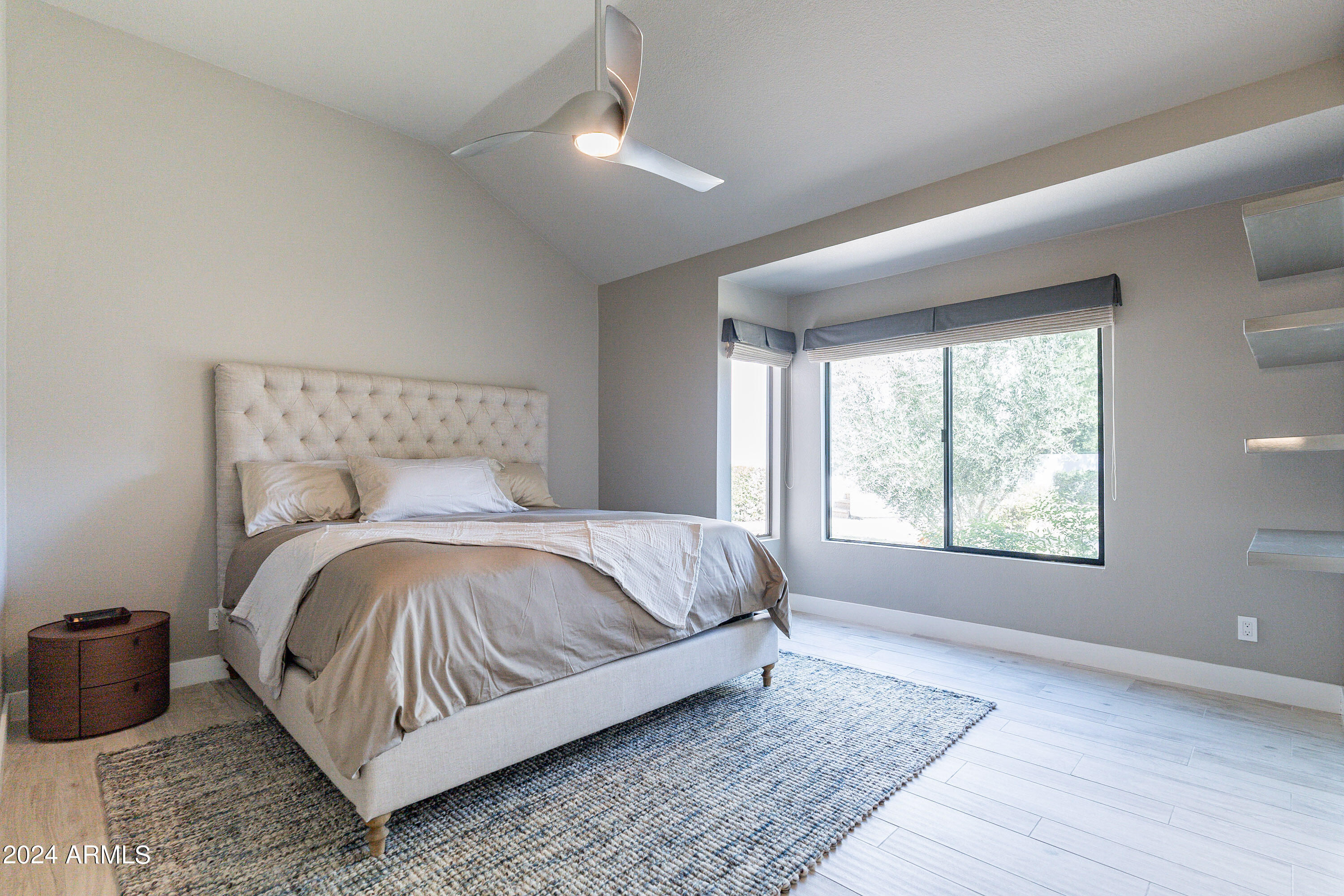 7272 East Gainey Ranch Road, Unit 101 Scottsdale, AZ 85258 - Photo 16 of 36 a bed sitting in a bedroom next to a window
