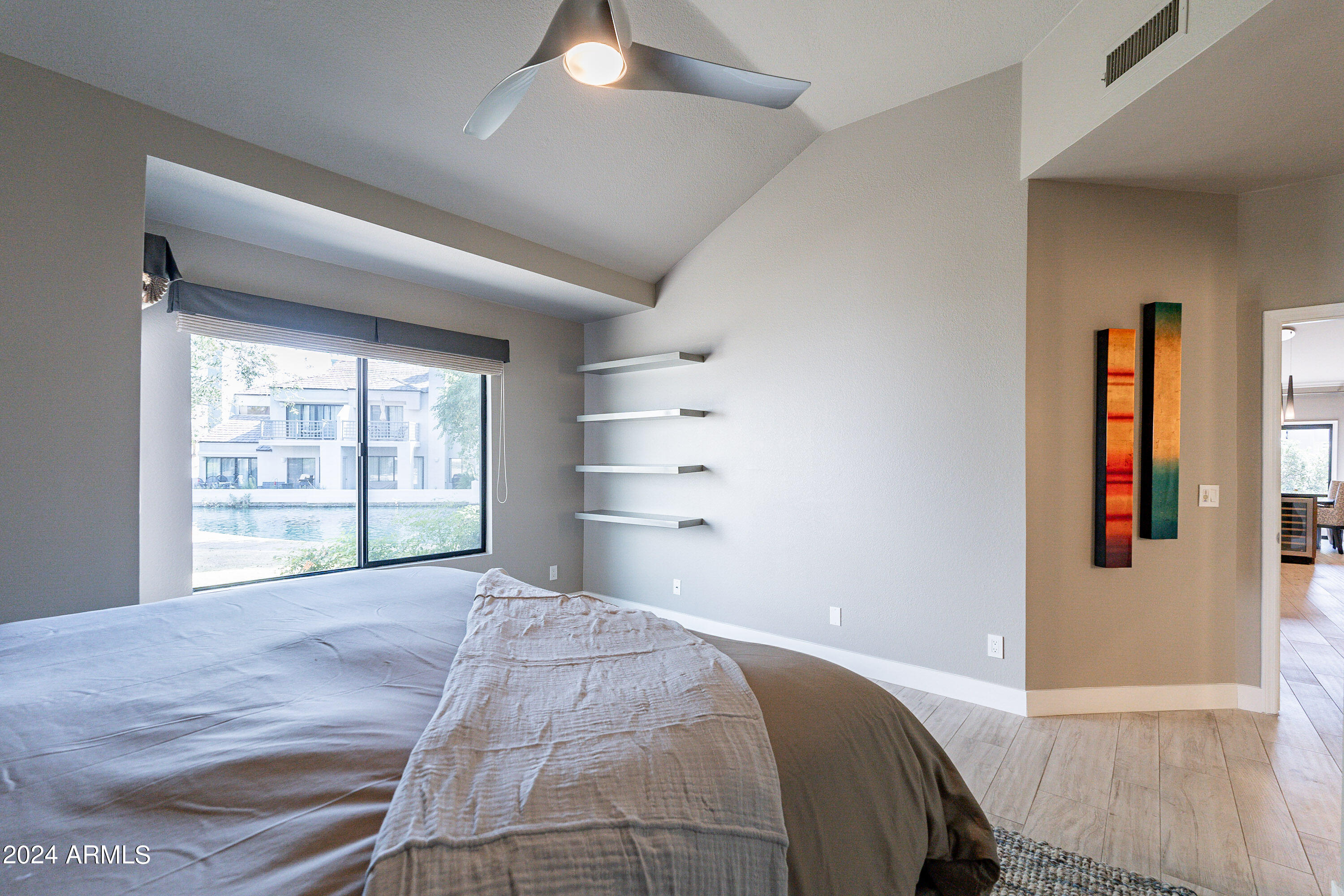 7272 East Gainey Ranch Road, Unit 101 Scottsdale, AZ 85258 - Photo 17 of 36 a bedroom with a bed and a large window