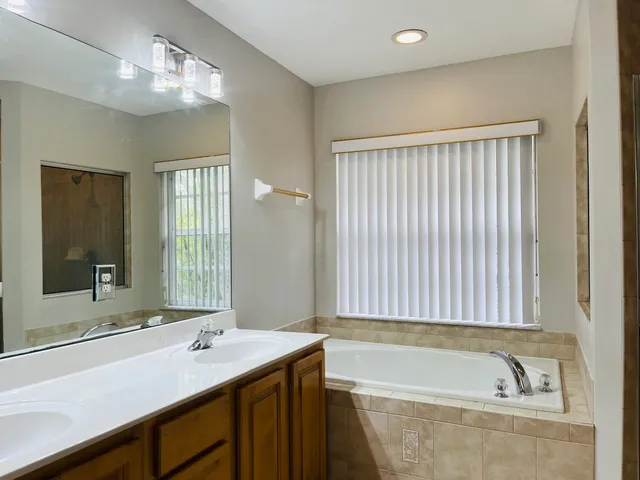 an empty room with wooden floor closet and windows