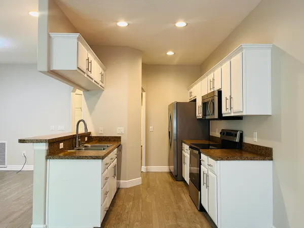 a kitchen with stainless steel appliances a sink stove and cabinets