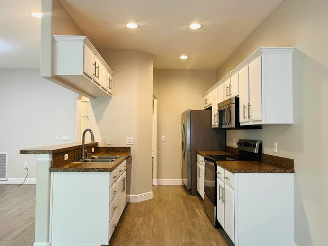 a kitchen with stainless steel appliances a sink stove and cabinets