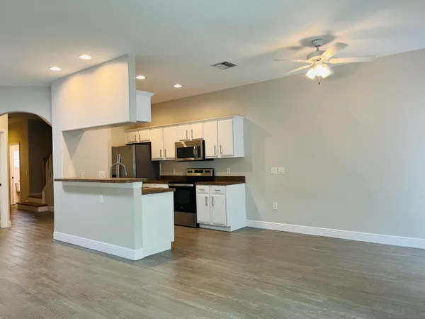 a kitchen with stainless steel appliances granite countertop a sink a stove and a refrigerator