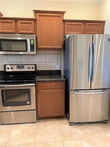 a kitchen with stainless steel appliances granite countertop a refrigerator and a stove top oven